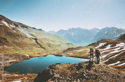 Couple backpackers hiking in mountains over lake Traveling together Lifestyle wanderlust concept adventure vacations outdoor aerial view. photo