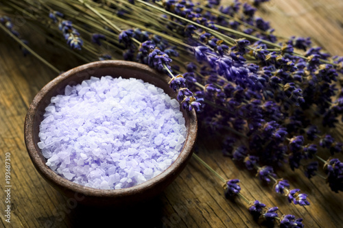 Lavender bath salt in wood bowl and lavender plant with purple flowers like wellness and spa concep 