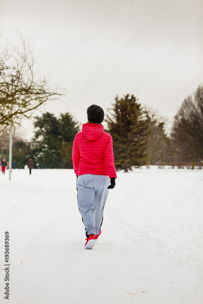 Woman wearing sportswear exercising outside during winter