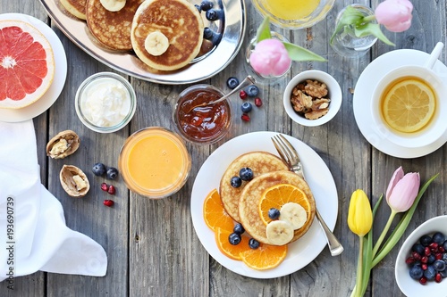 Pancakes. Breakfast set with pancakes, fresh berries, banana and various of topping. Overhead view, selective focus