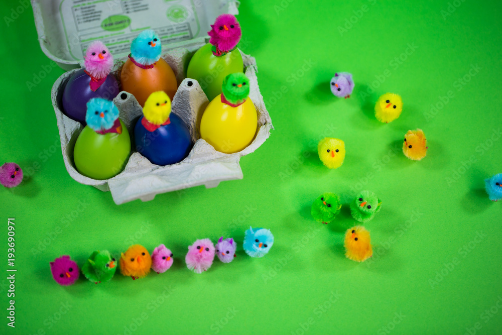 Eggbox with eggs and funny chicks, green background Eggbox with eggs and funny chicks, green background