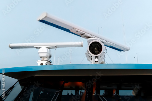 Rotating antenna of marine radar and a lantern on top of the ship. Closeup.