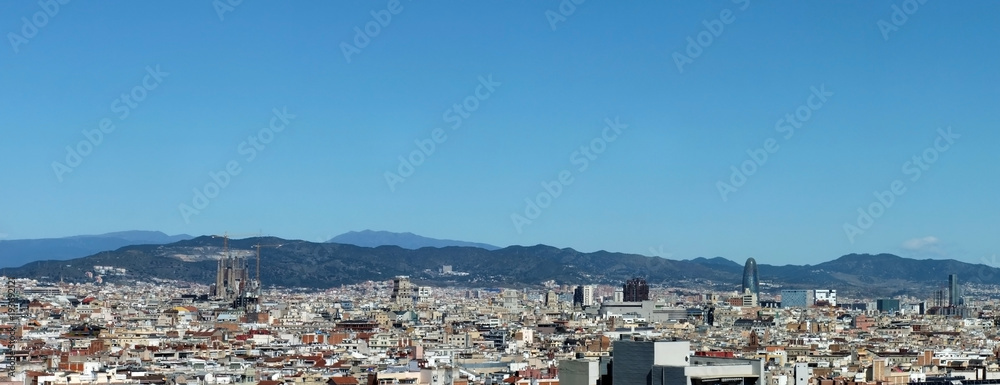 panorama of the city of barcelona showing the cathedral business district and housing with mountains in the distance