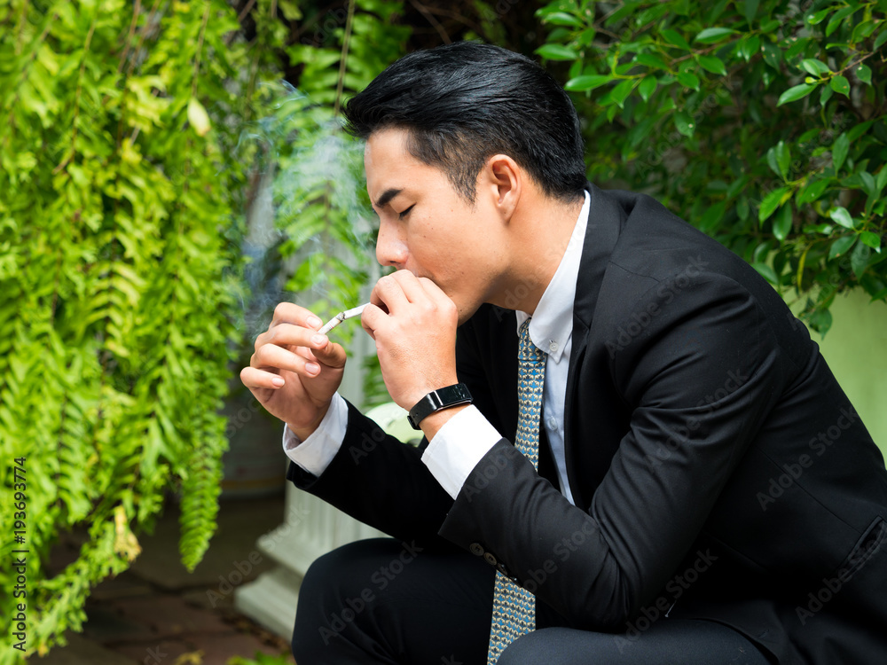 Young businessman smoking and thinking about business issues