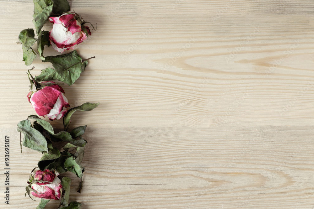 dried roses and leaves on wooden background with copy space, top view dried roses and leaves on wooden background with copy space, top view