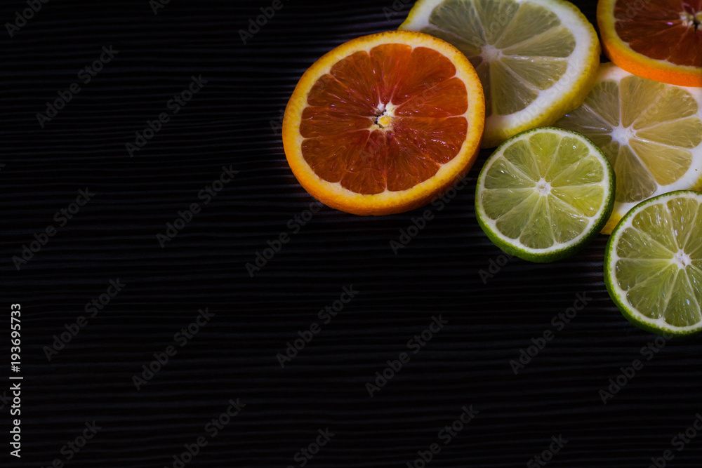 lemon, orange and lime on a black background lemon, orange and lime on a black background