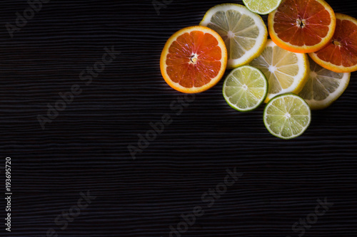 lemon, orange and lime on a black background