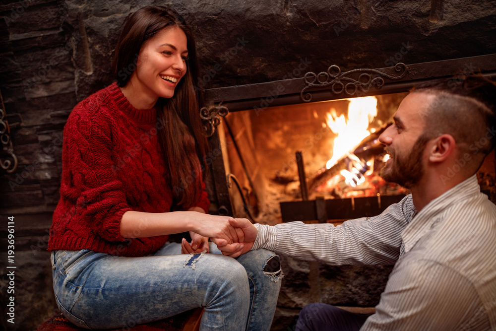 romantic couple sitting on the floor in front of fireplace romantic couple sitting on the floor in front of fireplace