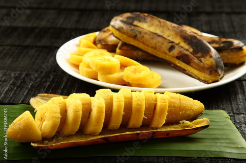 Sliced steamed bananas on a rustic table. photo