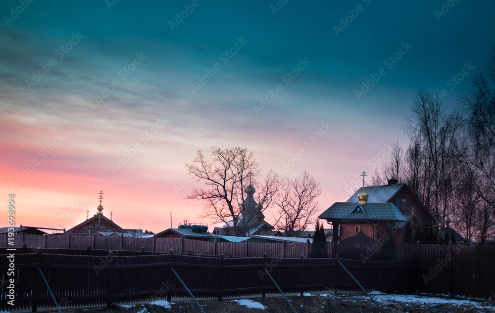  beautiful, colorful sunrise over wooden traditional buildings located in the middle of fields and backwaters, emerging from the reeds, seen in winter,