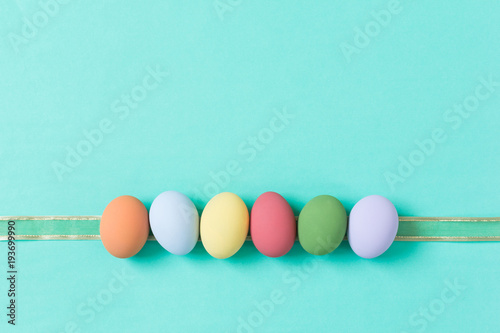 Canvas Print pastel easter eggs on green background in top view