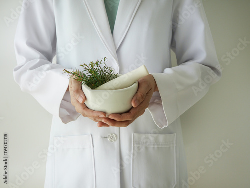 scientist or doctor making herbal medicine with herb leaves , capsule, tablets. hands.