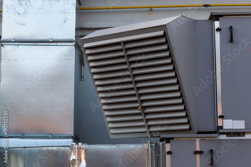 Close-up view of the ventilation louvres of the gray industrial ventilation unit standing outdoor photo