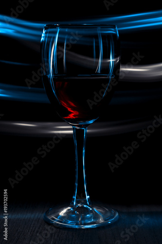 A glass of red wine. Dark background with bokeh effect. © Вячеслав Козырев