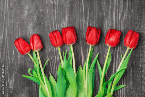 Red tulips on an antique wooden background