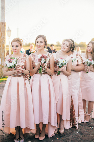 Obraz na płótnie Row of bridesmaids with bouquets at wedding ceremony. Beautiful girls in the same dress. w salonie