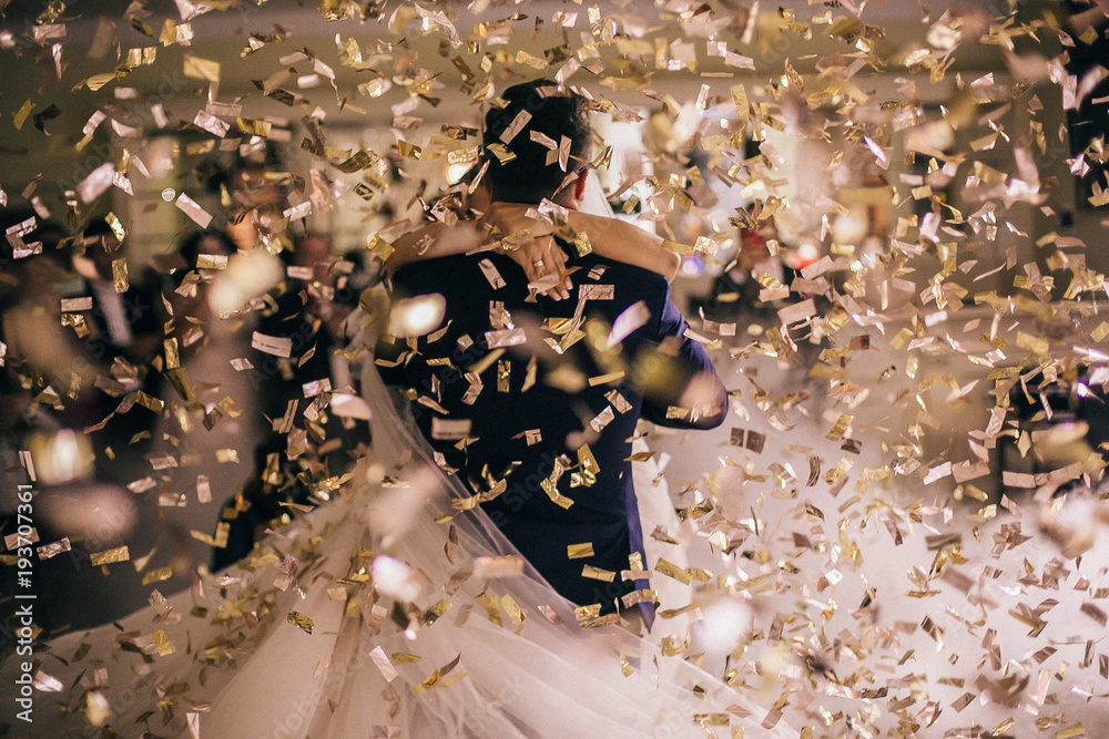 Wedding of beautiful caucasian couple just married and dancing their first dance. Bride and groom in wedding restaurant hall