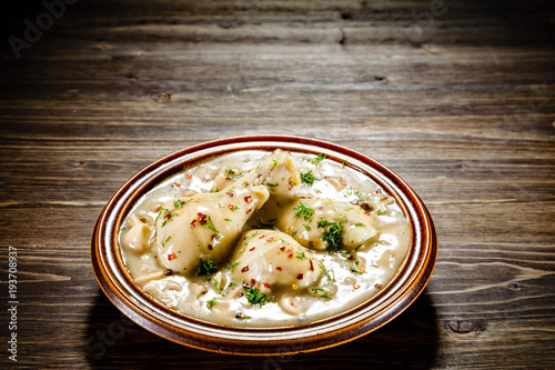 Chicken legs with champignon sauce on wooden table