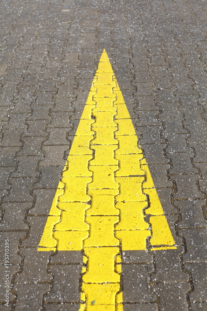Foto de Fahrbahnmarkierung Gelber Pfeil do Stock Adobe Stock
