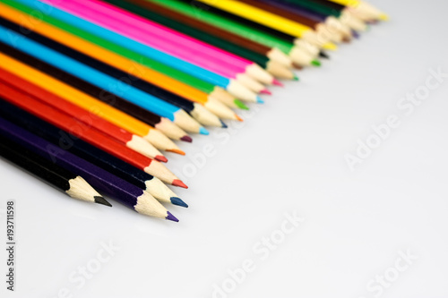Colored pencil crayons on white isolated ground. School accessories on a white table.