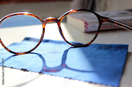 occhiali con panno e riflesso del sole photo