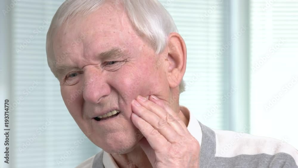 Unhappy senior man having toothache. Stressed elderly man with terrible toothache on blurred background close up. Unhappy senior man having toothache. Stressed elderly man with terrible toothache on blurred background close up.