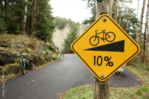 "Hill grade" warning sign posted for bicycles on path.