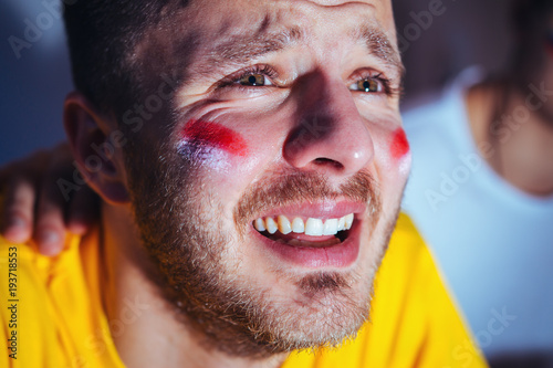 Sad, disappointing football fan crying, closeup  photo