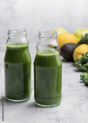 Healthy smoothie with kale in bottles on the table. Grey background. Organic. Healthy concept.