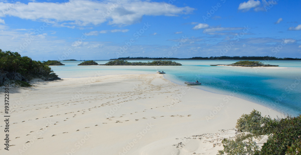 A tropical island with two dinghies and fresh footprints making for a private beach walk. Located near the sailboat anchorage of Norman's Cay in the Bahamas. A tropical island with two dinghies and fresh footprints making for a private beach walk. Located near the sailboat anchorage of Norman's Cay in the Bahamas.