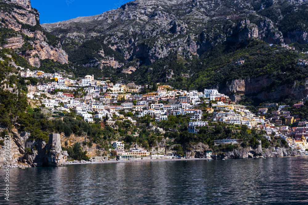 View from the sea to the Italian city with colorful houses on the mountains. Amalfi Coast - architectural and travel background