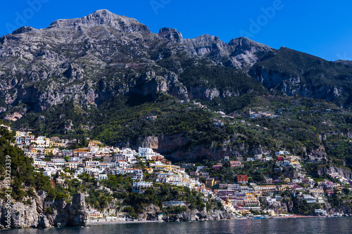 View from the sea to the Italian city with colorful houses on the mountains. Amalfi Coast - architectural and travel background © Ирина Селина