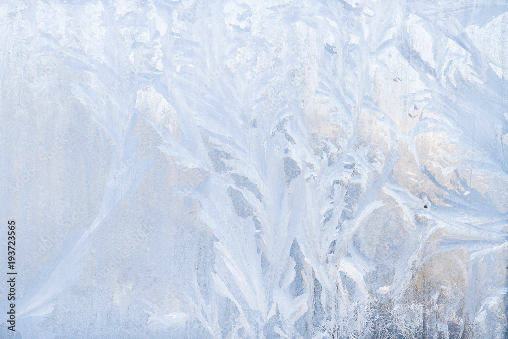 Fototapeta premium Winter frosty patterns on the frozen ice window