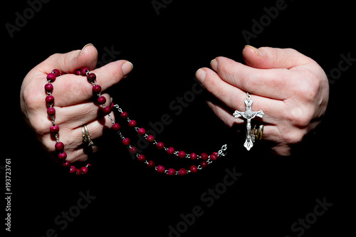 Female Hands Holding Rosary Beads Isolated on Black