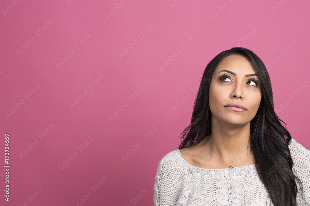 portrait of thoughtful young woman dressed in white sweater posing over pink background and looking aside to copyspace portrait of thoughtful young woman dressed in white sweater posing over pink background and looking aside to copyspace