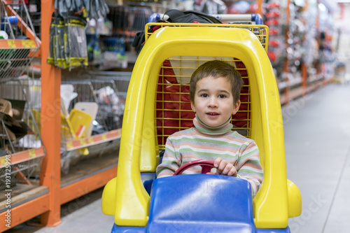 The boy is 4 years old in a construction shopThe boy is 4 years old in a construction shop, sitting in a cart.