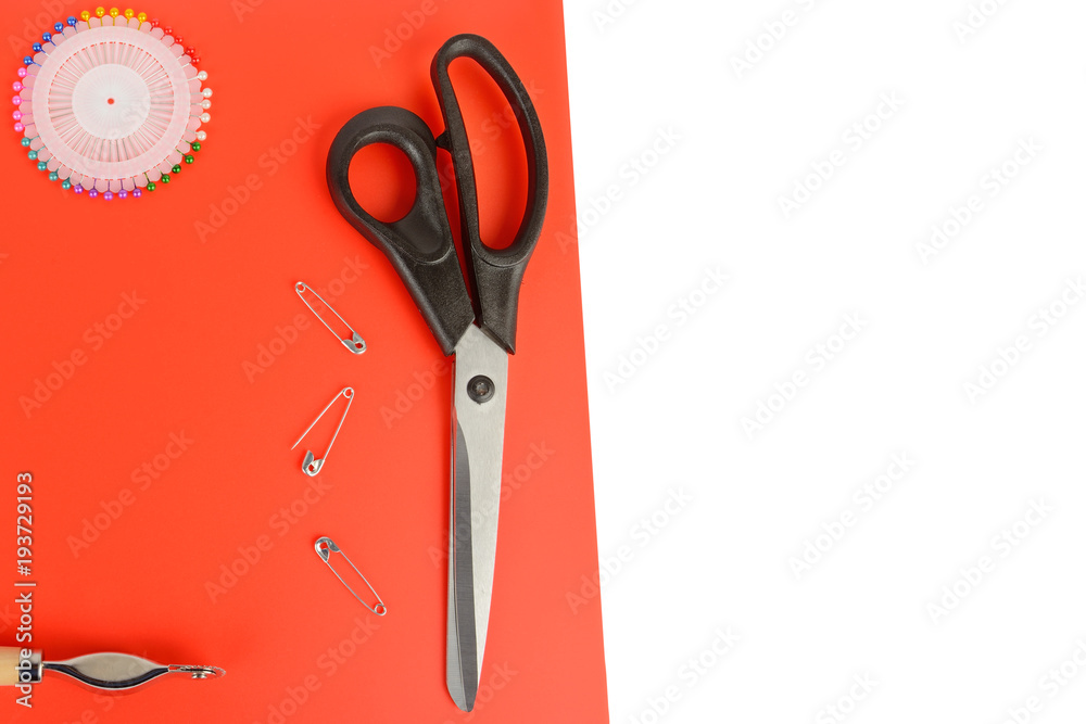 Tailoring scissors and pins on a red background. Free space for text. Tailoring scissors and pins on a red background. Free space for text.