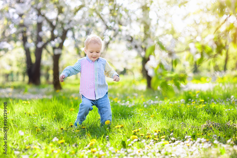 Child with cherry blossom flower. Easter egg hunt. Child with cherry blossom flower. Easter egg hunt.