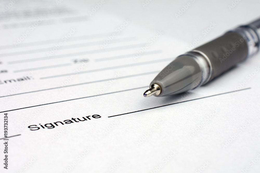 pen laying over a contract waiting to be signed pen laying over a contract waiting to be signed