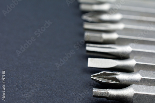 Set of heads for screwdriver (bits) Tools collection copy space, close up, selective focus. dark background