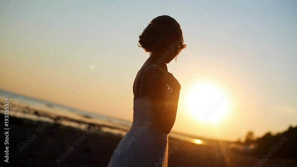 Bride walking at sunset at the beach Bride walking at sunset at the beach