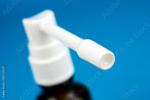 cough spray treatment of sore throat blurred blue background selective focus