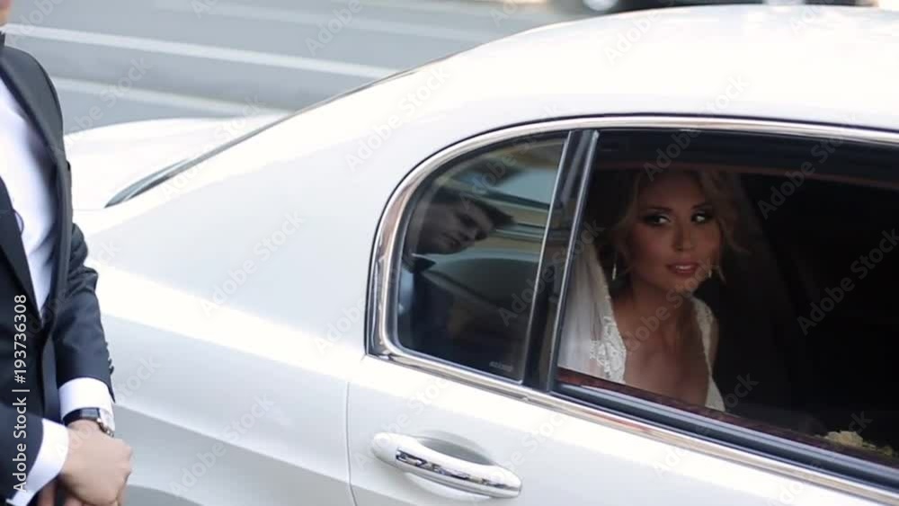 Young blonde bride sitting in white luxury wedding car Young blonde bride sitting in white luxury wedding car