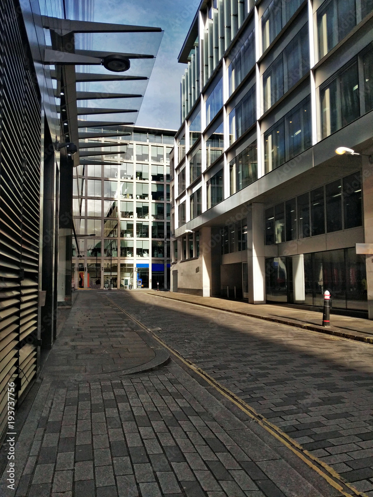 View along empty street of London with modern shopping and business office building View along empty street of London with modern shopping and business office building
