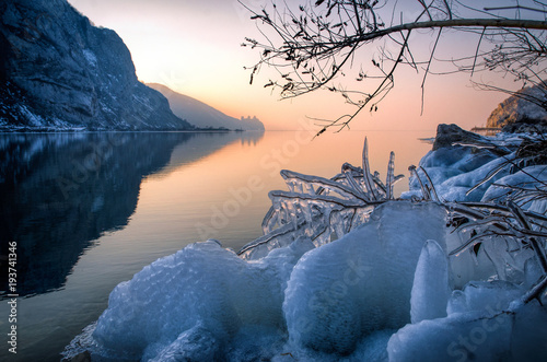 Icy Danube and fire sunset with Golubac fortress in the distance.
