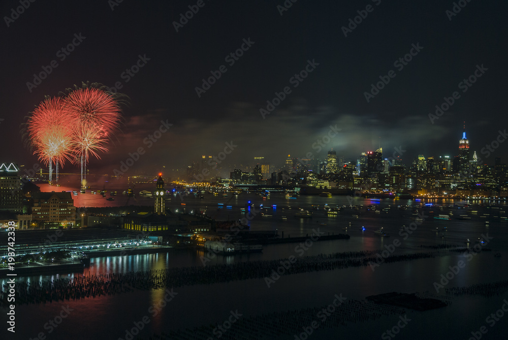 National day of America/Fire works and lots of boats on East River on the 4th of July against manhattans skyline as seen from New Jersey.