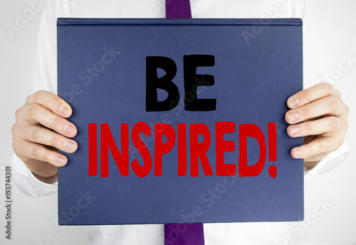 Writing text showing Be Inspired. Business concept for Inspiration, Motivation written on book notebook paper holding by the man in suit blurred background. photo