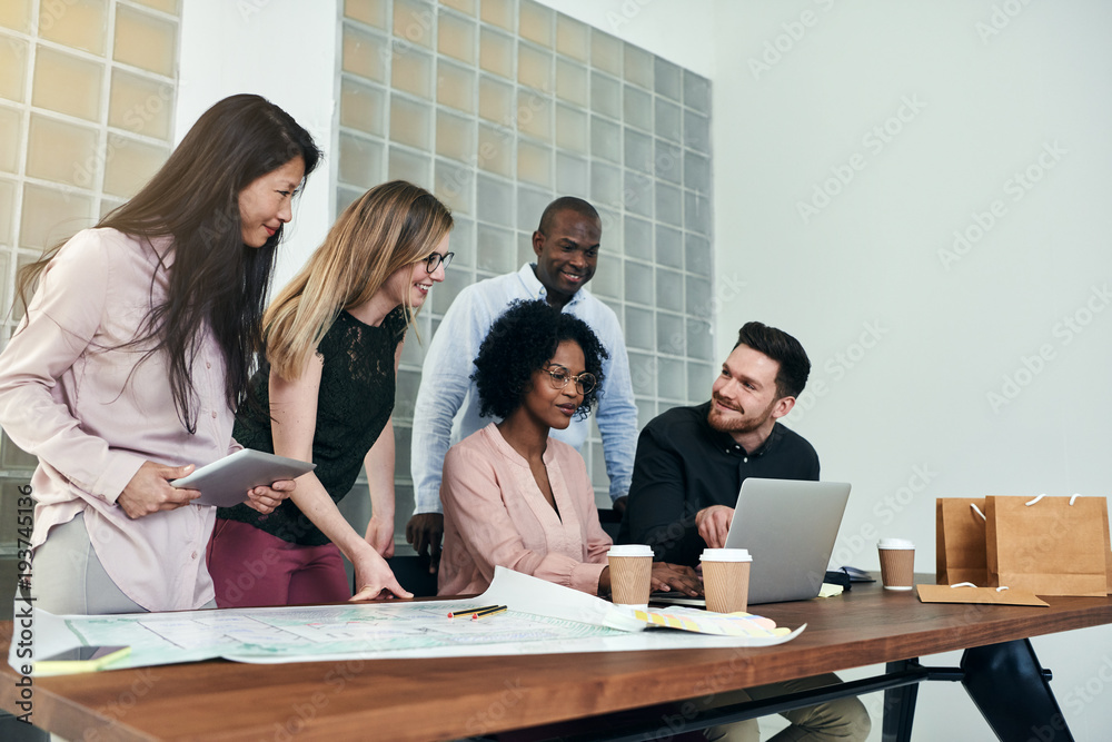 Group of smiling businesspeople working together around an office table Group of smiling businesspeople working together around an office table