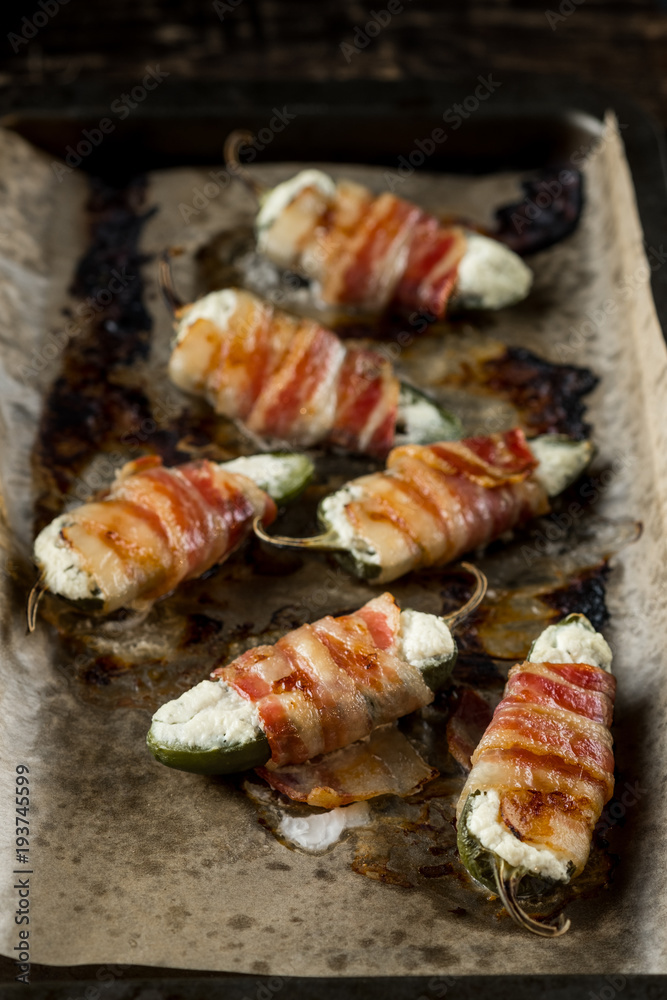 Vegetables stuffed with cheese and bacon and baked on tray in oven. Rustic recipe food on wooden background. Top view Vegetables stuffed with cheese and bacon and baked on tray in oven. Rustic recipe food on wooden background. Top view