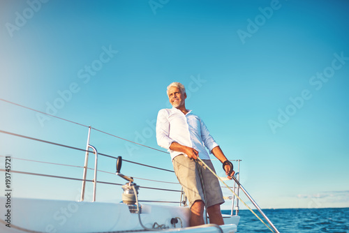 Smiling mature man enjoying a day sailing on the ocean